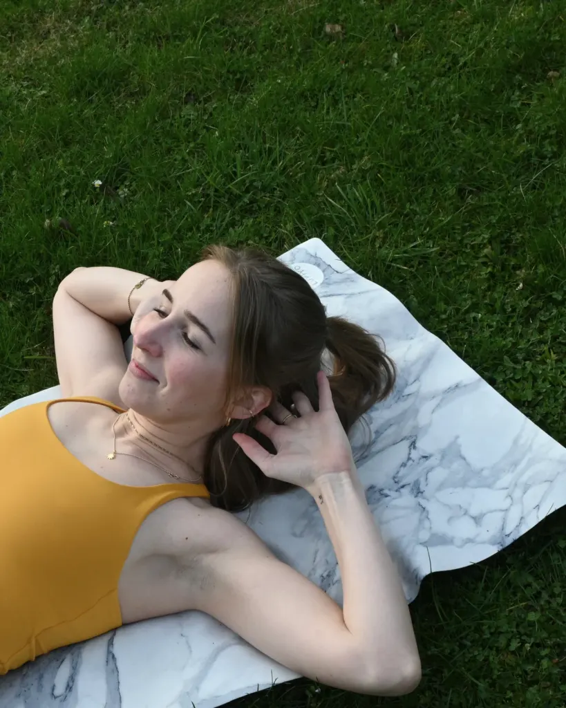 Sara Felsberg entspannt auf der Matte im Gras